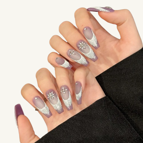 A set of long coffin press-on nails in matte taro purple, with silver brushed French tips and luxury ice crystal snowflake rhinestone charms.
