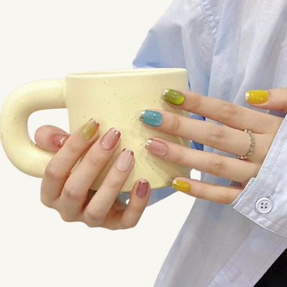 A set of colorful candy-colored press-on nails with a mirror French tip in silver and rose gold on short coffin fake nails.