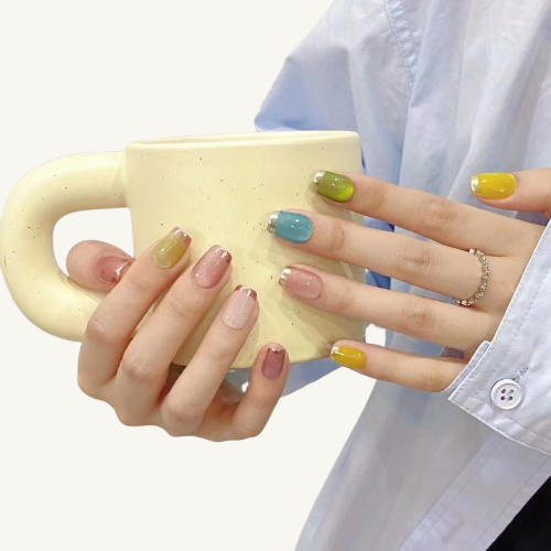 A set of colorful candy-colored press-on nails with a mirror French tip in silver and rose gold on short coffin fake nails.