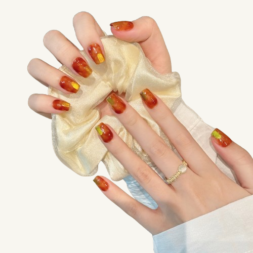 A set of handmade coffin press-on nails, translucent caramel brown jelly base with vertical gold glitter stripes.