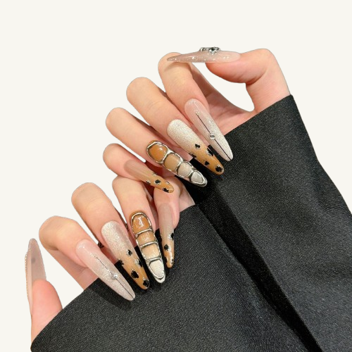 A set of Y2K punk style long stiletto  press-on nails, featuring a gothic cross, caramel leopard print, and a champagne cat-eye.