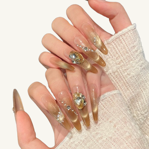 A set of handmade stiletto press-on nails, champagne cat-eye gradient, inlaid with a massive champagne gem and meteor-like crystals.
