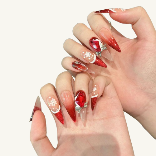 A set of Christmas-themed short stiletto press-on nails, with a ruby red ombre, Santa hat and snowflake cream French.