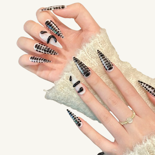 Hands wearing extra-long stiletto press-on nails with a 3D crocodile skin texture in black and white.