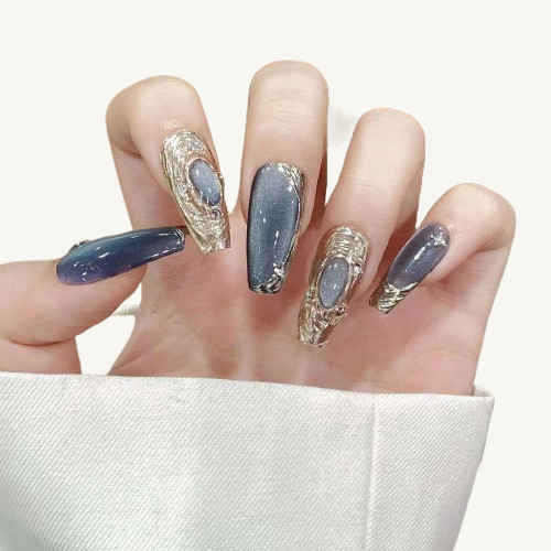A set of deep sea mermaid themed long coffin nails, featuring a grey-blue cat-eye and handmade 3D metal ornaments wrapping a gem.