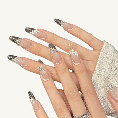 A morning dew themed handmade oval press-on set, nude pink cat-eye with clear French tips, adorned with crystal flowers.
