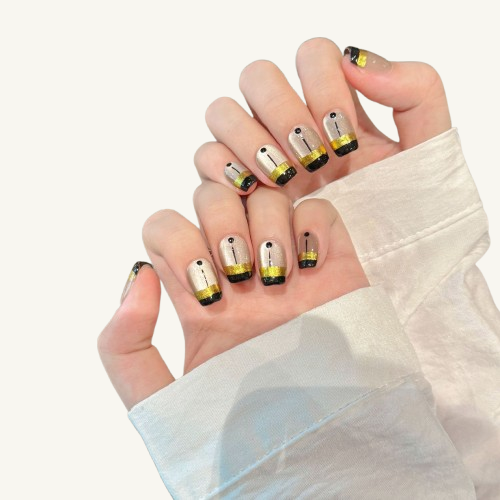 A geometric style set of handmade short coffin press-on nails featuring a silver-white cat-eye, black blocks, a wide gold band, and line art.