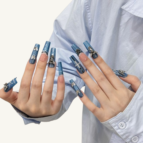 A set of gothic style long coffinnails with a blue denim texture base, handmade with vintage silver rose and cross charms.