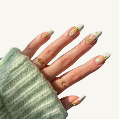A retro-inspired almond press-on nail set, showcasing a cottagecore vibe with its sage green and white daisy floral pattern.