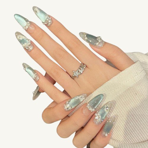 A set of long oval press-on nails with a mint green cat-eye effect, adorned with luxury pearls, rhinestones, and white 3D.