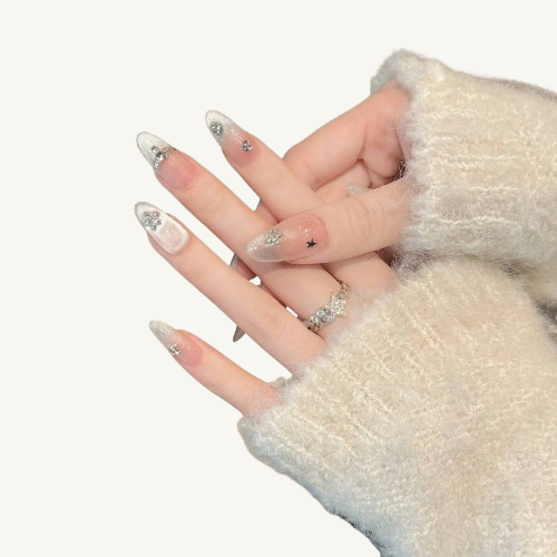 Hands wearing long almond press-on nails with a silver cat eye effect and ice crystal snowflake designs.