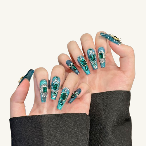 A mermaid-themed set of handmade long coffin press-on nails, teal glitter base, adorned with abundant emerald and clear crystals.