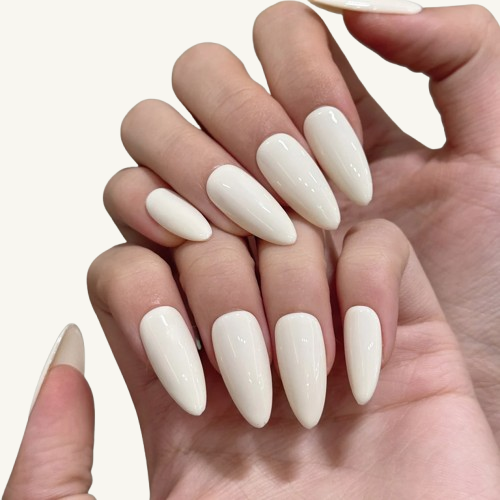 Hands wearing minimalist off-white, medium-long almond-shaped press-on nails, showcasing a clean solid-color manicure style.