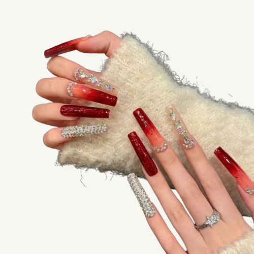A set of long coffin press-on nails with a red glitter ombre, a full diamond AB crystal nail, and a luxury jewelry chain.
