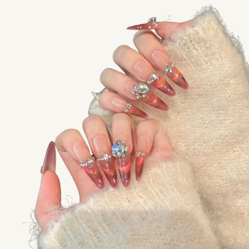 A set of handmade jelly-look press-on nails, nude-to-rose gradient cat-eye, embellished with crystals and a heart-shaped diamond.