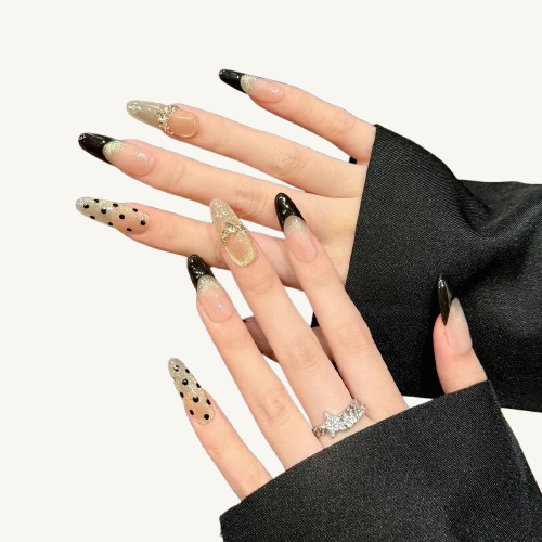A chic handmade oval press-on set, mixing black polka dots, black French tips, and a crystal star band on a champagne gold glitter base.