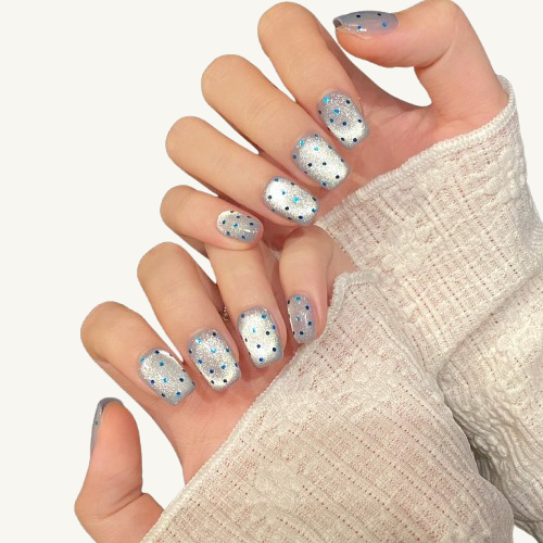 A summer-style handmade coffin press-on set, icy silver glitter base with lake-blue polka dots.