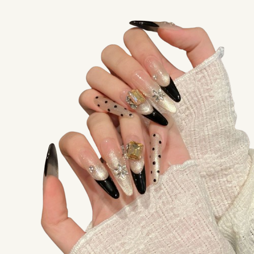 A vintage-style handmade stiletto press-on set, champagne cat-eye with black French tips, adorned with crystal flowers and a square gem.